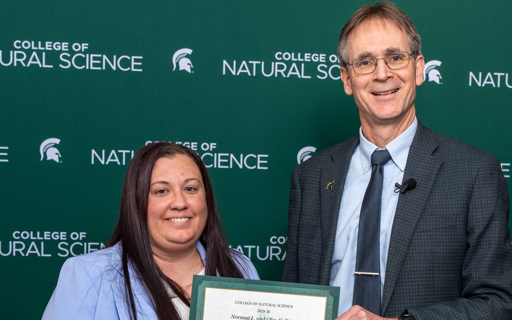 Dean Eric Hegg awarding Dr. Henderson the College's Excellence in Teaching Award